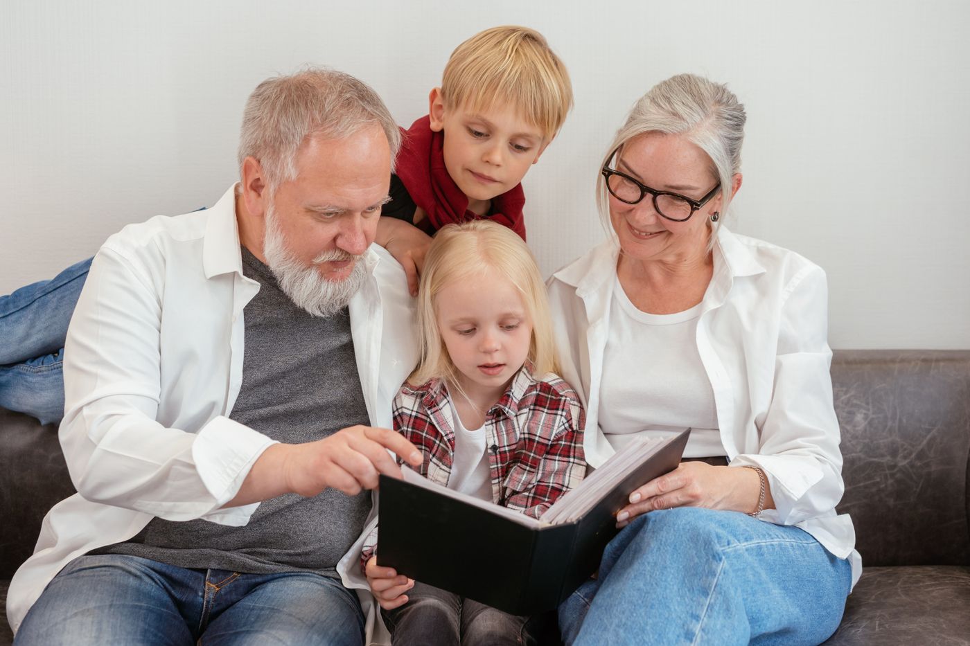 Grands-parents et petits-enfants regardant un album photo