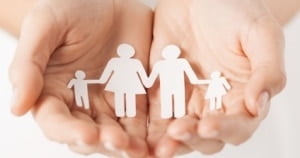 womans hands with paper man family