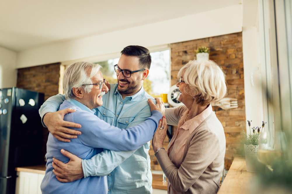 Parents Agés Heureux qui Embrassent Leur Fils Adulte